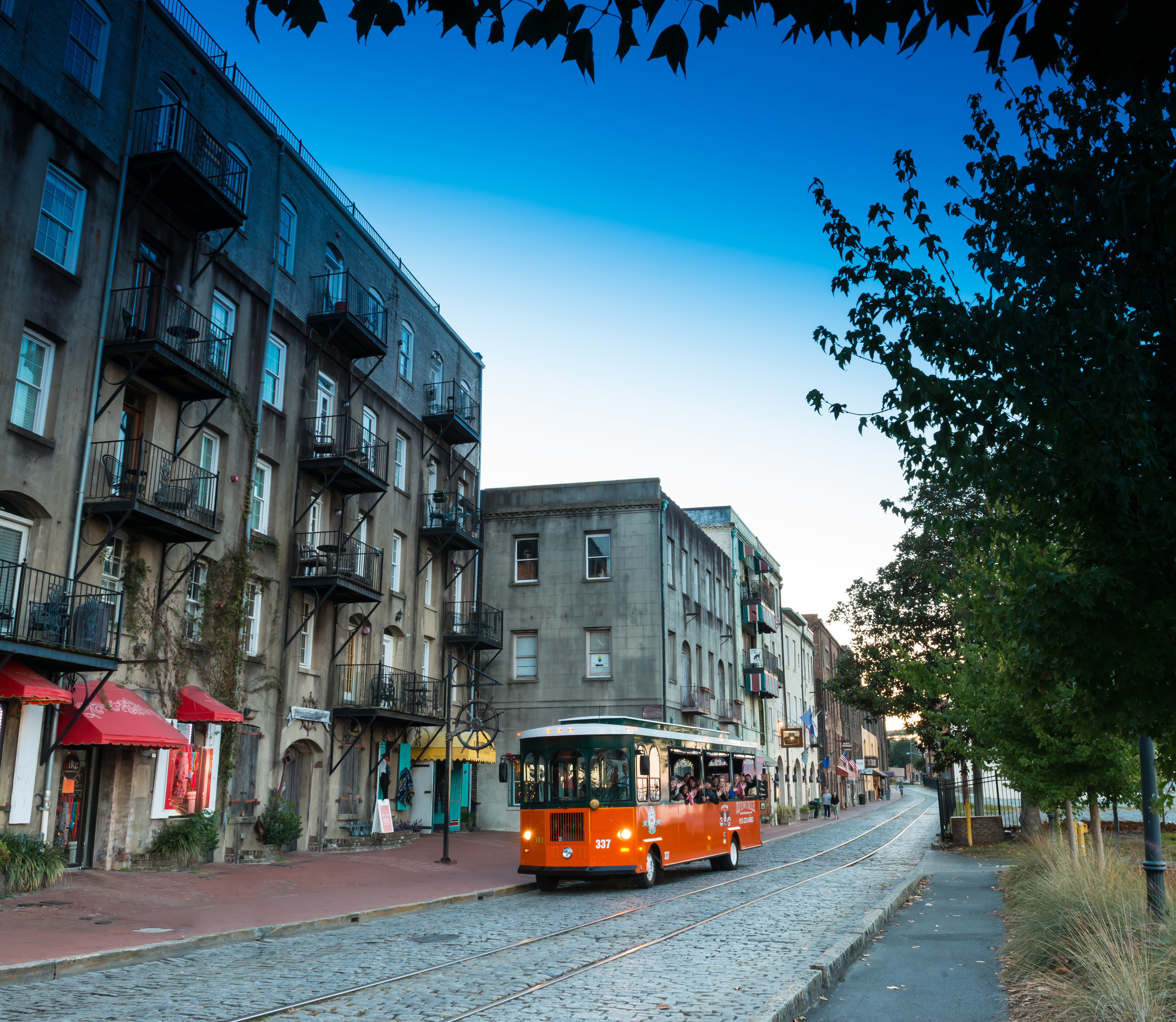 A tour trolley drives along the Savannah cobblestone streets at dusk. A tour trolley drives along the Savannah cobblestone streets at dusk.