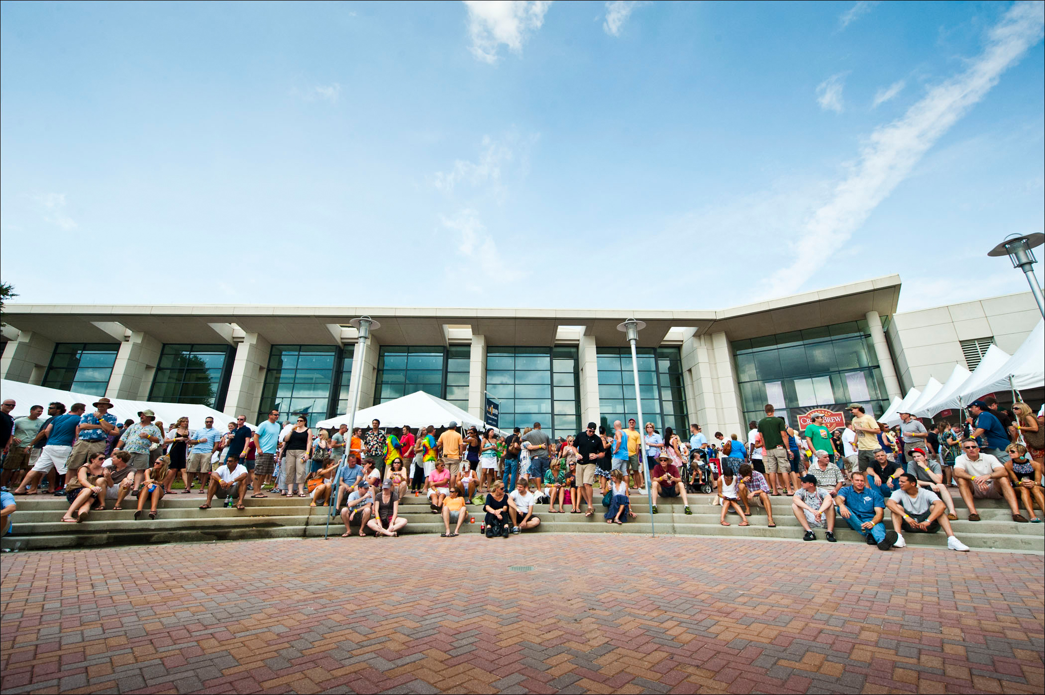 A large group of event attendees sit on the stairs outside the Savannah Convention Center under blue skies. A large group of event attendees sit on the stairs outside the Savannah Convention Center under blue skies.